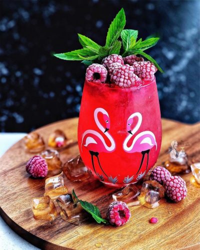 A Berry Lime Spritz Cocktail with some fresh raspberries and mint