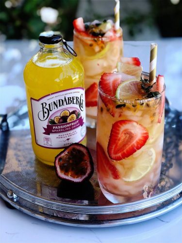 Passionfruit Pimms Cup with Bundaberg Passionfruit garnish with fresh thyme, passionfruit, strawberries and lime